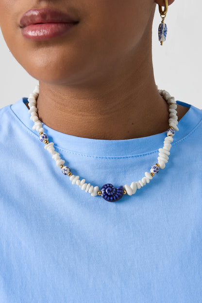 Ketting met stenen kralen, witte kralen met blauwe bloemetjes en statement schelp